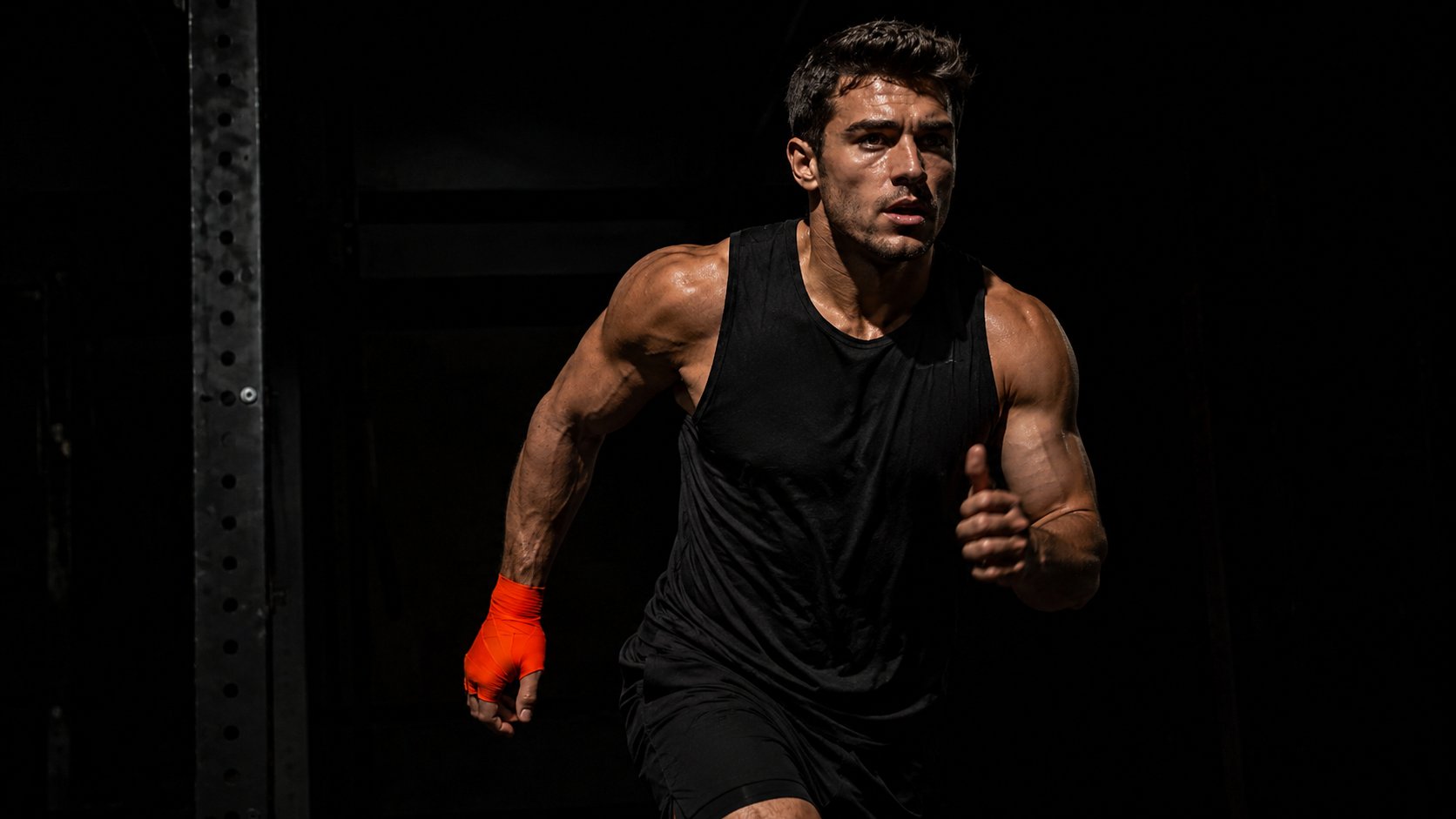 Athlete in motion mid-session, second wind phase, dark gym with directional lighting