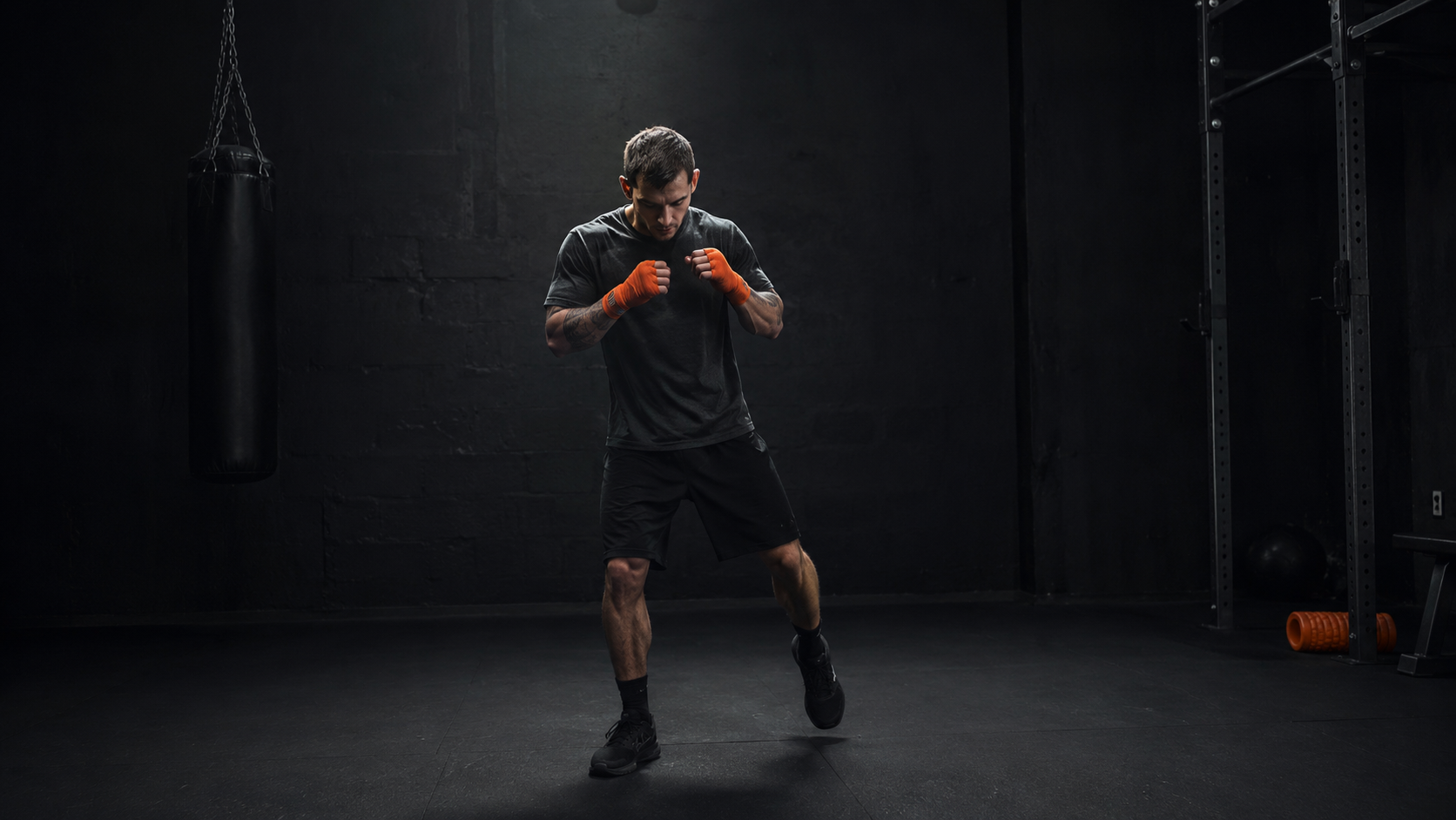 Athlete warming up in dark gym, attentive early-session movement, diagnostic moment before training begins