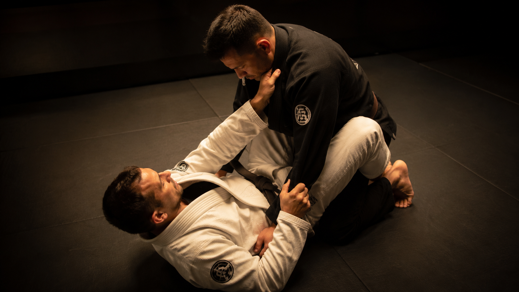 BJJ athletes grappling on dark mat with tungsten light, sleep deprivation and athletic performance