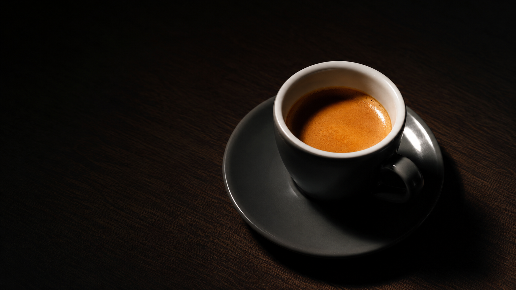 Single espresso cup on dark surface, tungsten light, caffeine and sleep deprivation mechanism